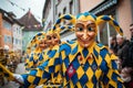 Cheerful fool figures in yellow and blue robes march in a large group